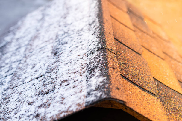 Солнце нагревается на коричневой битумной черепице крыши в снегу - Фото, изображение