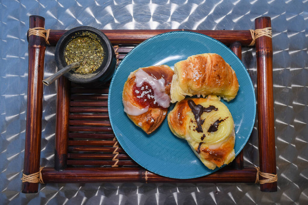 felső kilátás egy hangulatos és ízletes reggeli rusztikus tálca egy társ és néhány sütemények és croissant - Fotó, kép
