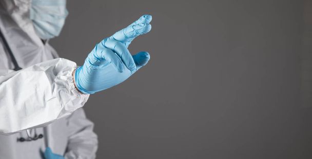 doctor presses a finger on a virtual screen on a gray background - Photo, image