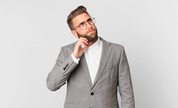 young handsome man thinking, feeling doubtful and confused. business concept - Photo, image