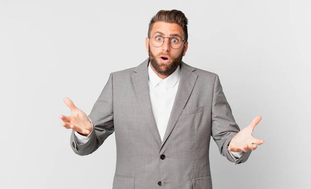 young handsome man feeling extremely shocked and surprised. business concept - Photo, Image