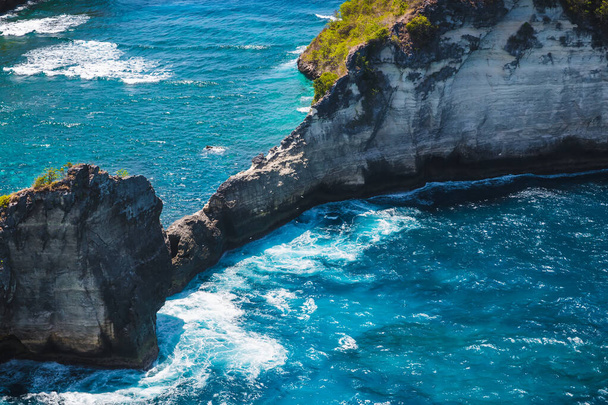 Kameny v modrém oceánu poblíž ostrova Nusa Penida. Bali, Indonésie.  - Fotografie, Obrázek
