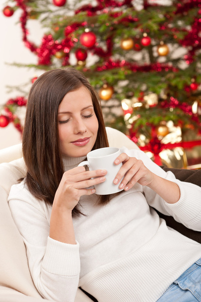 Brown hair woman relaxing with coffee on Christmas in front of Christmas tree - Foto, Imagen