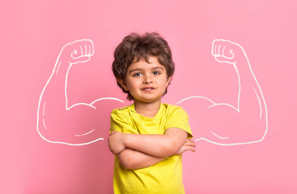 Strong little man child with bicep muscles picture. Concept for strength, confidence or defense from bullying. Kindergarten or school kid. Strong boy - Photo, Image