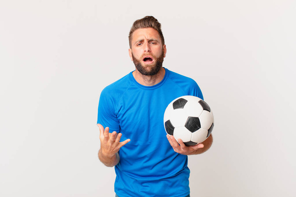 young handsome man looking desperate, frustrated and stressed. soccer concept - Fotoğraf, Görsel