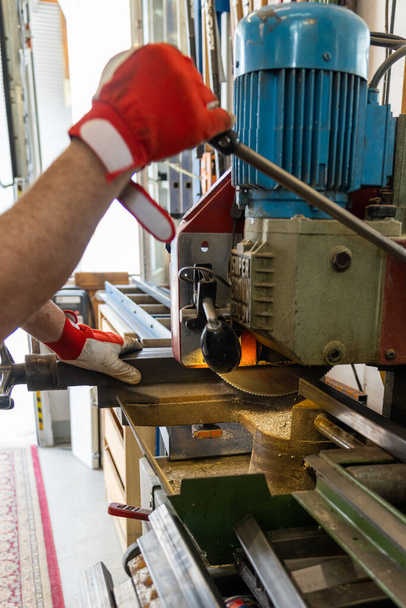 Um metal trabalhador corte de aço com uma serra de fita de aço - Foto, Imagem