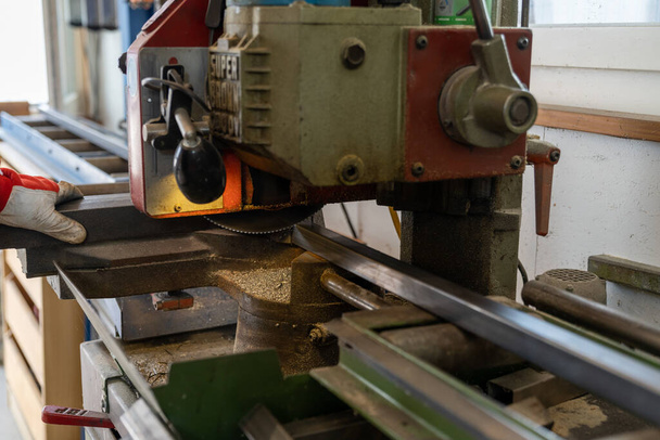 Ein Metallarbeiter schneidet Stahl mit einer Stahlbandsäge - Foto, Bild