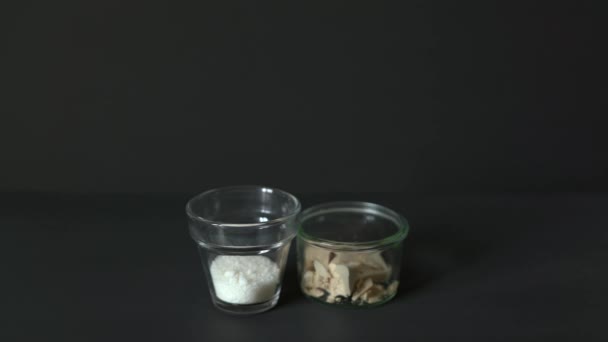 Sklenice mléka na černém stole s cukrem a kvasinkami - Záběry, video