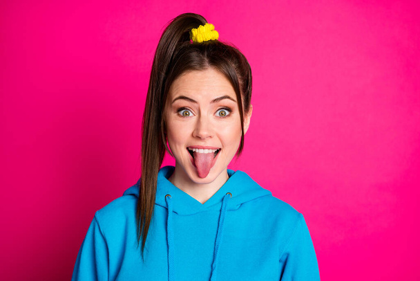 Portrait of cool tail hairstyle young lady show tongue out smile look camera isolated on pink color background - Zdjęcie, obraz