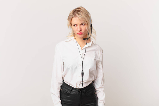 young pretty woman feeling sad, upset or angry and looking to the side. telemarketing concept - Photo, Image