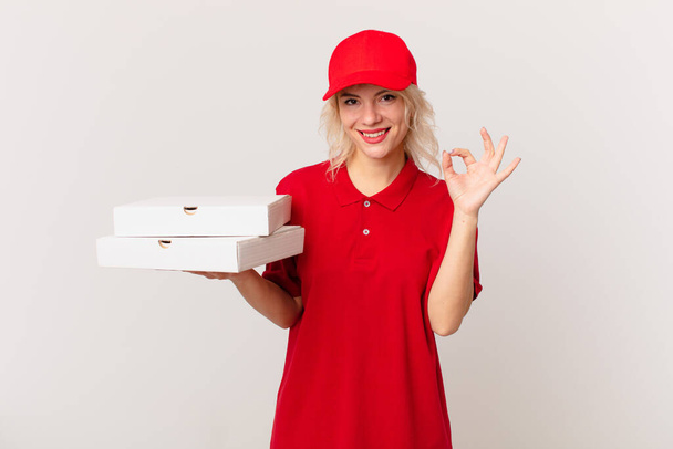 νεαρή όμορφη γυναίκα αισθάνεται ευτυχισμένη, επιδεικνύοντας την έγκρισή της με εντάξει χειρονομία. έννοια παράδοσης πίτσας - Φωτογραφία, εικόνα