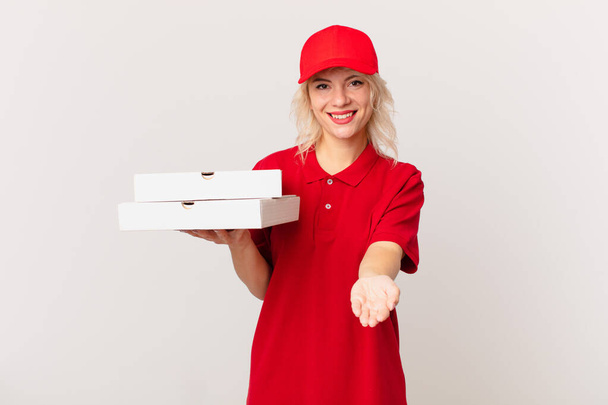 young pretty woman smiling happily with friendly and  offering and showing a concept. pizza delivering concept - Fotografie, Obrázek