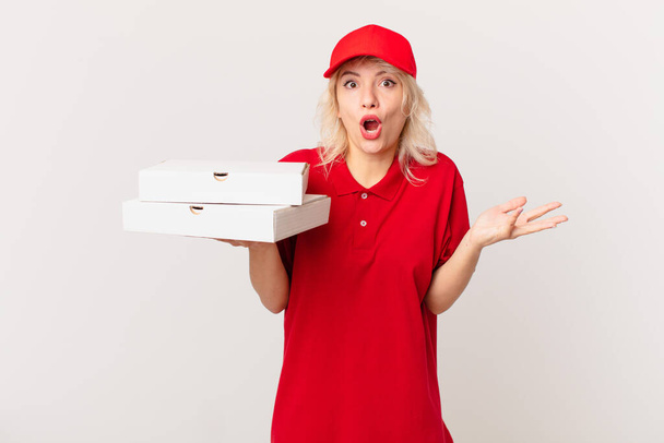 young pretty woman amazed, shocked and astonished with an unbelievable surprise. pizza delivering concept - Foto, afbeelding