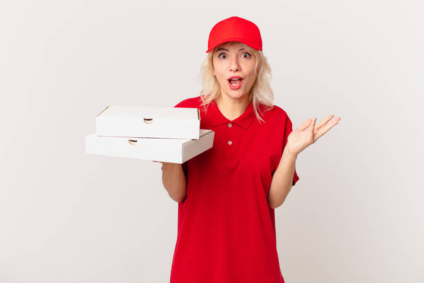 young pretty woman feeling extremely shocked and surprised. pizza delivering concept - Fotoğraf, Görsel