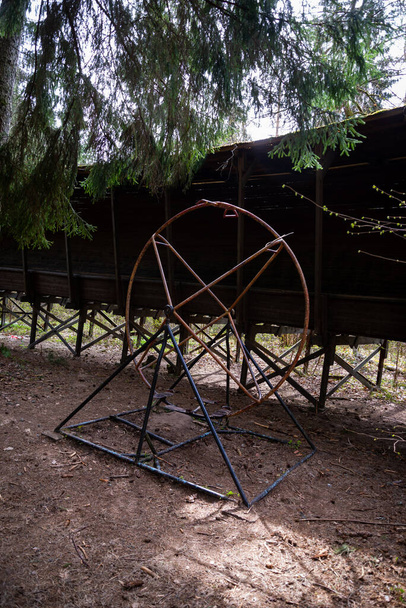 Construction of an old abandoned metal children's playground in the forest. Spring - Photo, Image