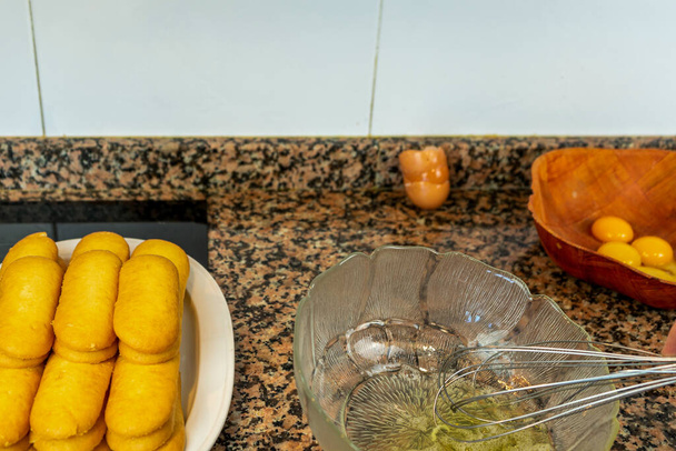 Uitzicht op de handen bereiden van de crème om een Tiramisu taart te maken in de keuken thuis. Voederconcept - Foto, afbeelding