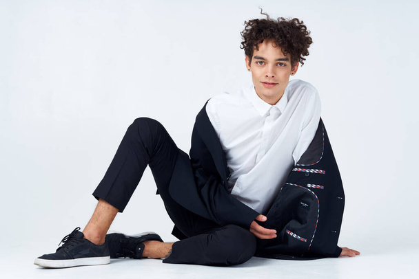 guy sitting on the floor curly hair suit modern style  - Photo, Image