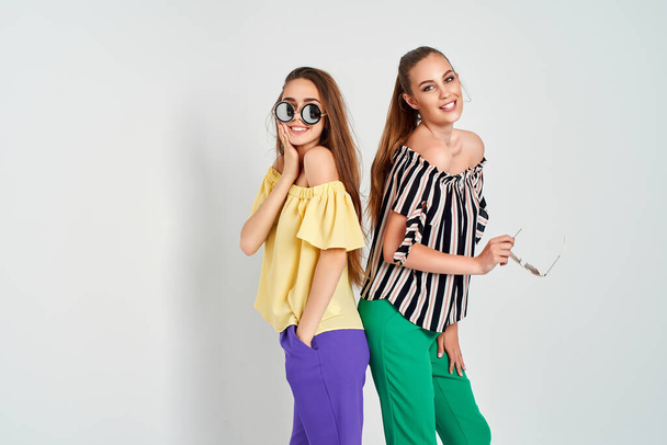 Two young women in stylish clothes fashion beauty studio shot on white background - Photo, image