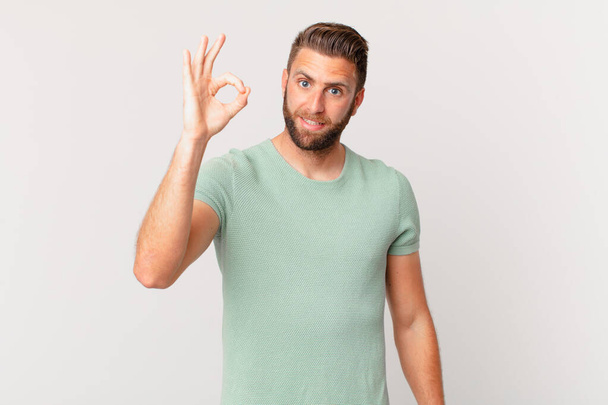 young handsome man feeling happy, showing approval with okay gesture - Fotoğraf, Görsel
