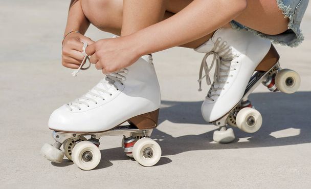 Close-up detail of skater's hands tying the laces of a roller skate - Photo, Image