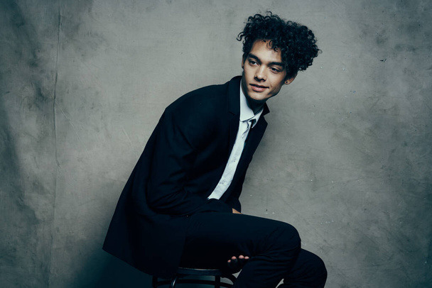 Cheerful curly-haired guy in a suit fashion business official - 写真・画像