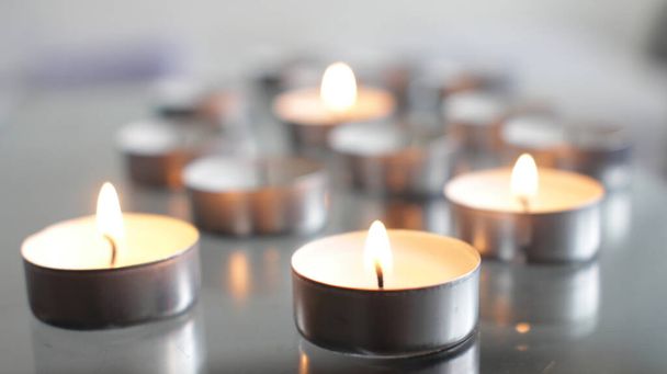 Čajové svíčky hořící na průhledném stole za denního světla - Fotografie, Obrázek
