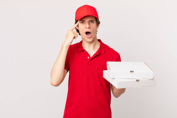 pizza deliver man looking surprised, realizing a new thought, idea or concept - Foto, imagen