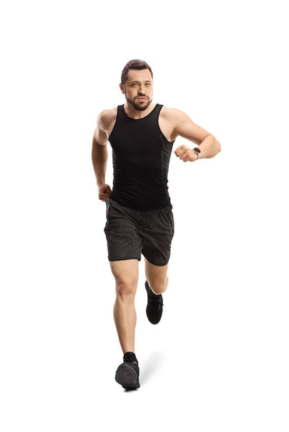 Full length portrait of a fit young man with a smartwatch running towards camera isolated on white background - Photo, image