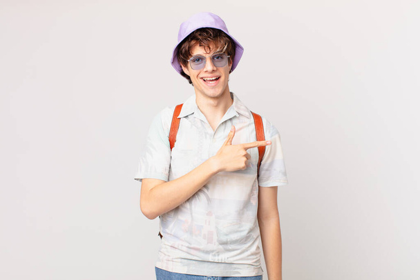 young traveller or tourist man looking excited and surprised pointing to the side - Φωτογραφία, εικόνα