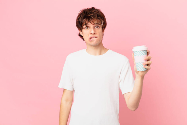 young man with a coffee looking puzzled and confused - Fotoğraf, Görsel