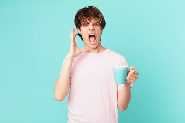 young man with a coffee mug screaming with hands up in the air - Foto, imagen