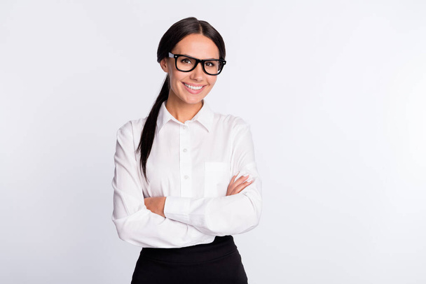 Photo of optimistic brunette hairdo lady crossed arms wear spectacles white shirt isolated on grey color background - 写真・画像