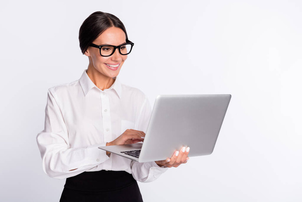 Photo of optimistic brunette hairdo lady hold laptop wear spectacles shirt isolated on grey color background - Foto, Bild