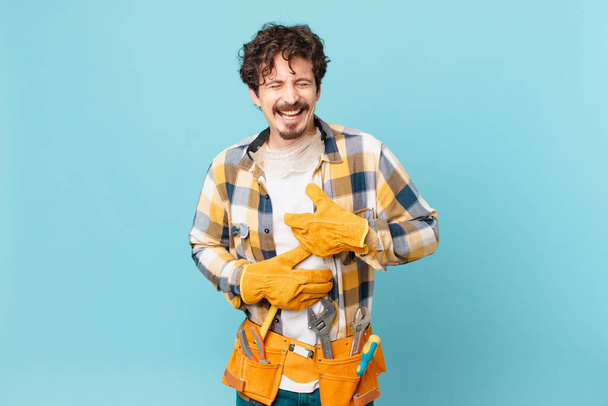 young handyman housekeeper laughing out loud at some hilarious joke - 写真・画像