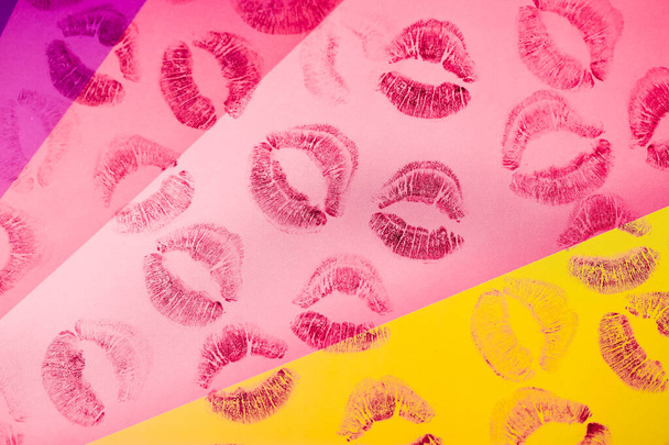 Abstract purple red lipstick kisses on yellow pink art background. Lots of prints of women's lips on paper. Beautiful lips stamps isolated. Valentines day, romantic love concept. Lipstick kisses. - Photo, Image