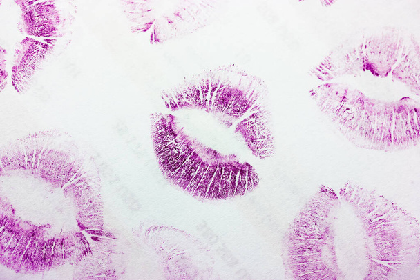 Streszczenie fioletowe pocałunki izolowane na białym tle. Dużo kobiecych odcisków warg na papierze. Piękne neonowe znaczki na ustach. Walentynki, romantyczny nastrój i koncepcja miłości. Szminkowe pocałunki. Odcisk warg - Zdjęcie, obraz