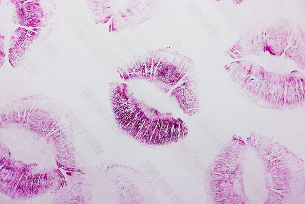 Streszczenie fioletowe pocałunki izolowane na białym tle. Dużo kobiecych odcisków warg na papierze. Piękne neonowe znaczki na ustach. Walentynki, romantyczny nastrój i koncepcja miłości. Szminkowe pocałunki. Odcisk warg - Zdjęcie, obraz