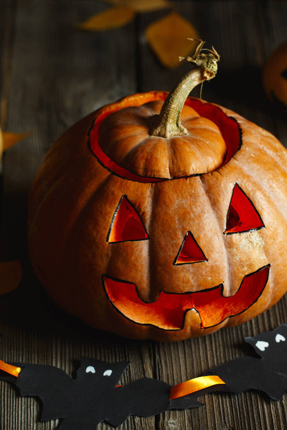 Halloween design tökkel. A Halloween szörnyű szimbóluma - Jack-o-lamptern. Ijesztő tökfej lánggal és néhány kis festett tökkel. Ragyogó arc, csokit vagy csalunk. Halloween barkácsolás - Fotó, kép