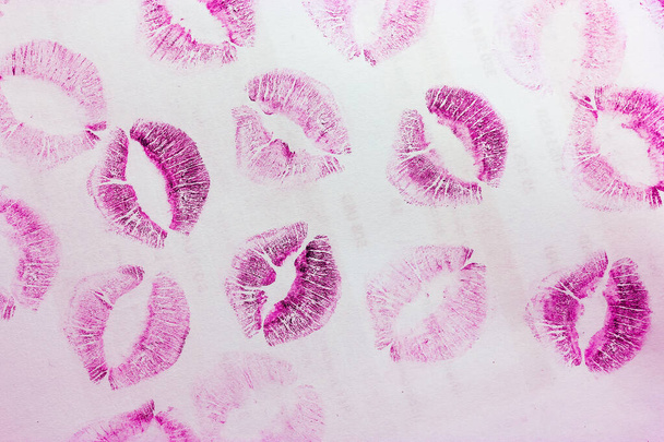 Abstract pink kisses isolated on white background. Lots of female lip prints on paper. Beautiful neon lips stamps. Valentine's day, romantic mood and love concept. Lipstick kisses. Print of lips - Photo, Image