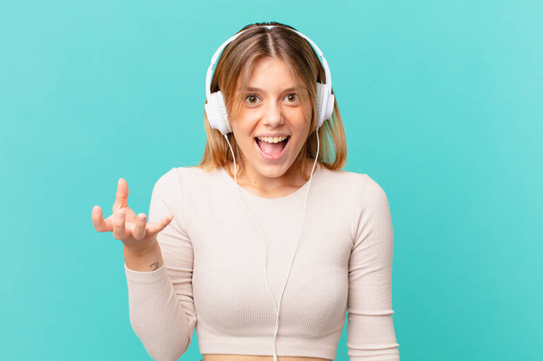young woman with headphones looking angry, annoyed and frustrated - Photo, image
