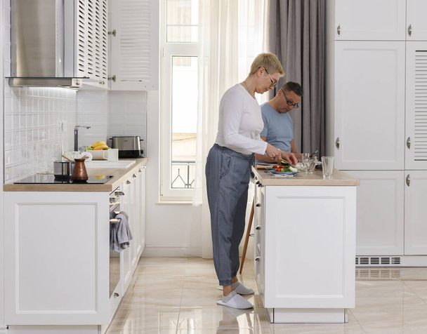 Plná délka boční pohled starší pár vaří v kuchyni. Šťastný rodinný portrét - Fotografie, Obrázek