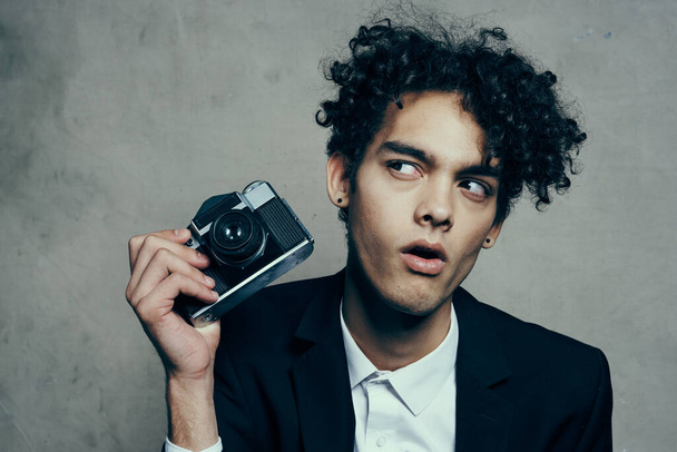 handsome guy in a suit with a camera lessons curly hair emotions model - Φωτογραφία, εικόνα