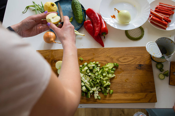 Samice ručně krájené okurky na rustikální kuchyňský stůl, vaření a vegetariánská koncepce. - Fotografie, Obrázek