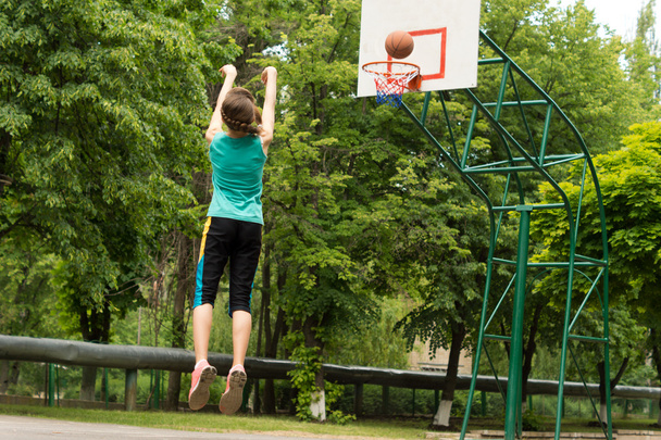 Skilled young basketball player shooting a goal - Φωτογραφία, εικόνα