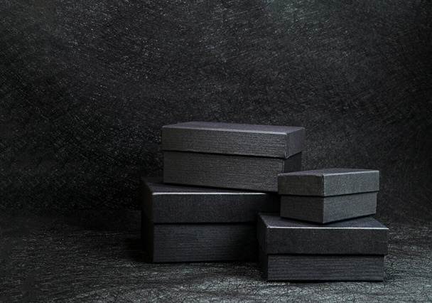 Four Black boxes gifts on black background - Foto, Imagen