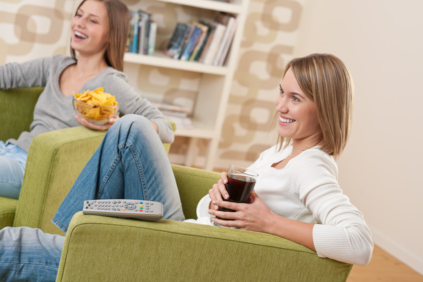 Students - Two smiling female teenager watching television toget - Фото, зображення