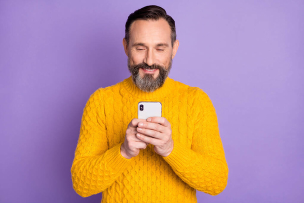Photo of positive man arms hold phone typing comment have good mood isolated on violet color background - Foto, imagen
