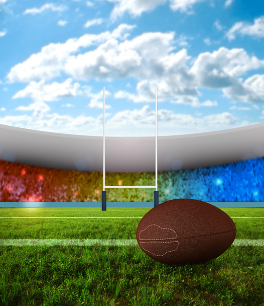 Rugby ball on field with stadium of background - Photo, Image