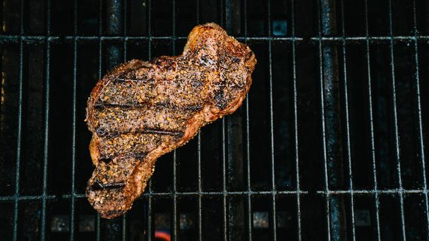 NY strip steak grilling on barbeque grill from above - Photo, Image