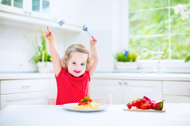 roztomilé batole dívka jíst špagety v bílé kuchyni - Fotografie, Obrázek